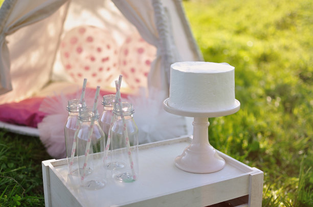 奶油蛋糕户外儿童照片与装饰和瓶子在日落图片下载