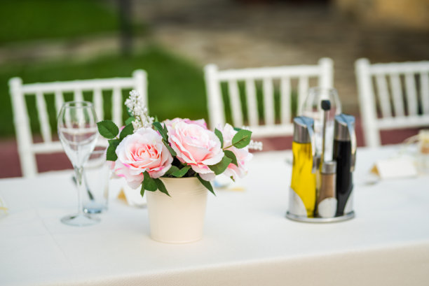 婚礼餐桌布置好。户外桌子设置-婚礼/派对桌子与鲜花。图片下载