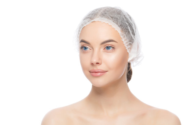 侧肖像的年轻美丽的女人站着戴着医疗帽，准备手术，孤立在白色的背景图片下载