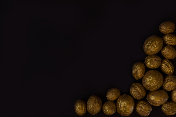 圣诞黑色背景与金色核桃。圣诞节极简主义背景与坚果。文本复制空间图片下载
