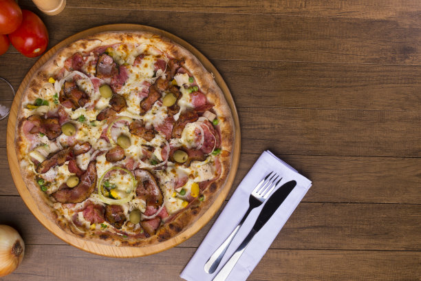 美味的葡萄牙比萨由火腿，豌豆蛋，棕榈心，意大利辣香肠，洋葱，马苏里拉奶酪和培根制成。装在木板上。特写照片。文本和图形艺术空间。图片下载