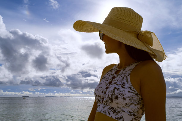 一名亚洲女子在晴朗的日子穿着比基尼和海帽在沙滩上图片下载