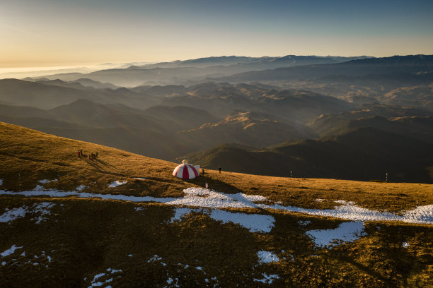 这是一个美丽的秋日，在罗马尼亚布加勒斯特山脉2170米高的地方，一个徒步旅行者观看日落的无人机照片图片下载