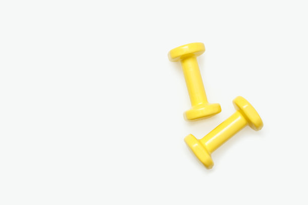 白色背景上孤立的黄色哑铃。从以上观点。图片下载