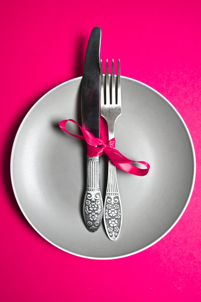 餐具用丝带系在粉红色的背景上图片下载