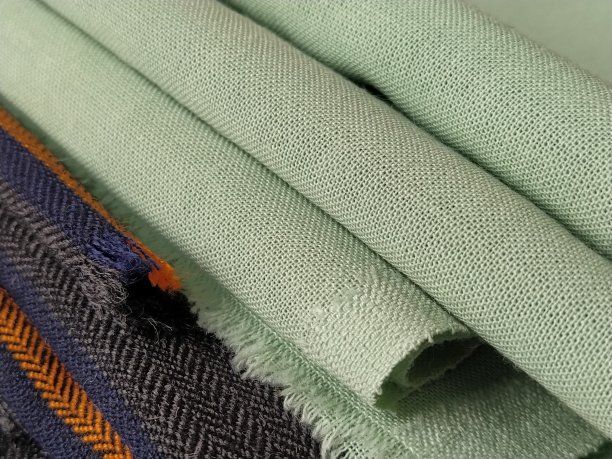 绿色和黑色条纹的布料叠成一堆。特写镜头图片下载