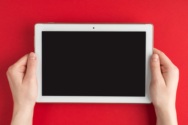 技术开发。顶部上方俯瞰照片的女性手握平板电脑孤立在红色背景与copyspace图片下载