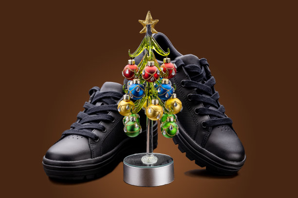 黑色时尚运动鞋套装装饰圣诞树孤立在棕色的背景。鞋业圣诞促销模板图片下载