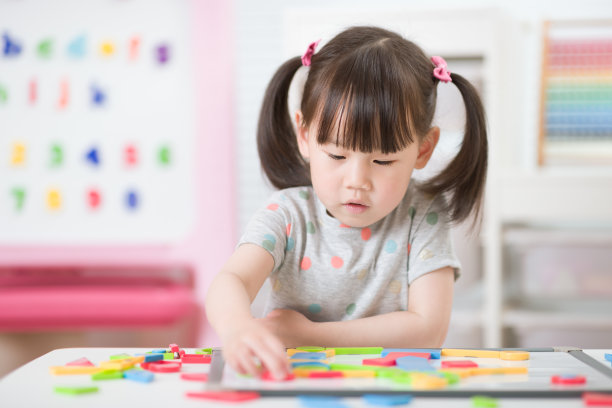 年轻女孩玩创造性玩具积木在家上学图片下载