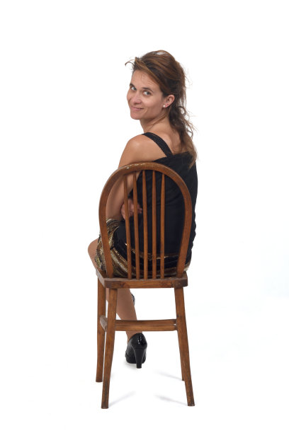 一个女人的后视图在白色的背景上坐在椅子上的裙子图片下载