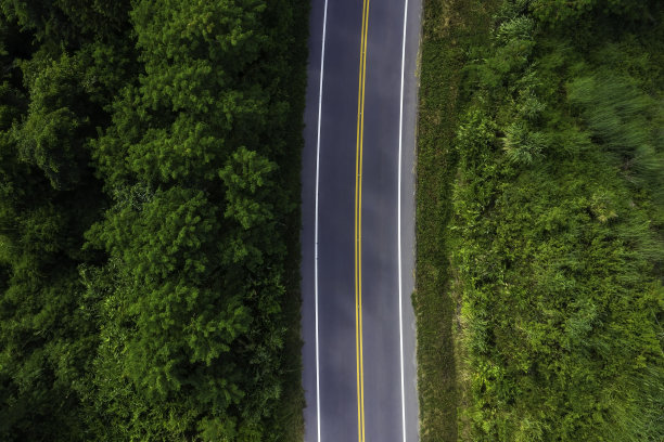 航拍俯视图公路通过绿色的森林和纹理背景为公路的空荡图片下载