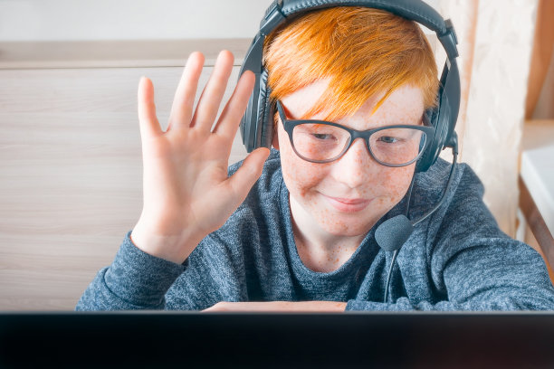 一个十几岁的男孩在家用笔记本电脑做作业。使用小工具学习的孩子。儿童教育和远程教育。隔离期间在家教育网络会议图片下载