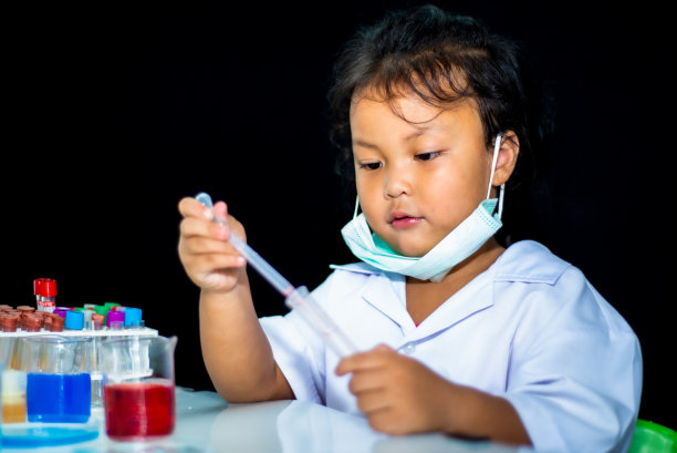 亚洲小女孩工作烧杯和化学测试分析在实验室的黑色背景。图片下载