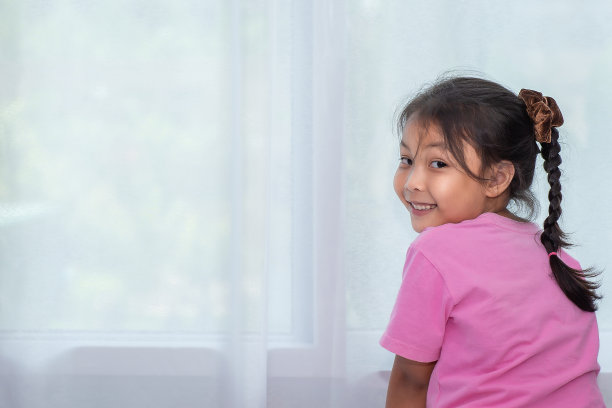 居家隔离时快乐的亚洲小女孩（社交隔离，新冠疫情下的新常态）图片下载