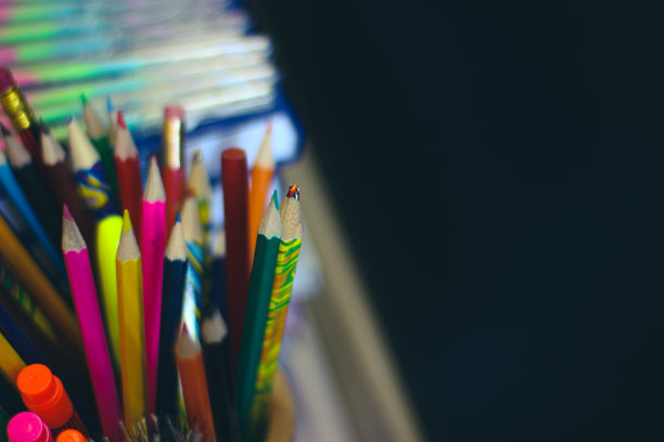 在学校黑色黑板的背景上涂上铅笔和钢笔。在黑板上放一个拷贝空间。图片下载