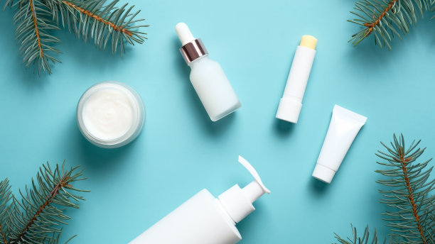 冬季护肤理念。一套化妆产品在柔和的蓝色背景。平躺，俯视图。图片下载