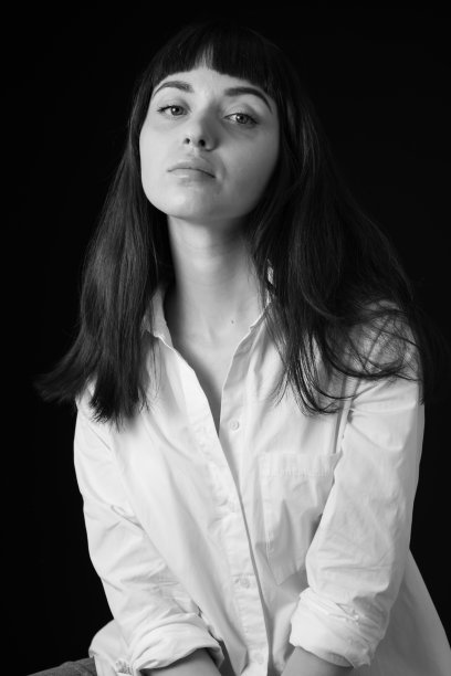 一个年轻女子的画室肖像，背景是纯黑色图片下载