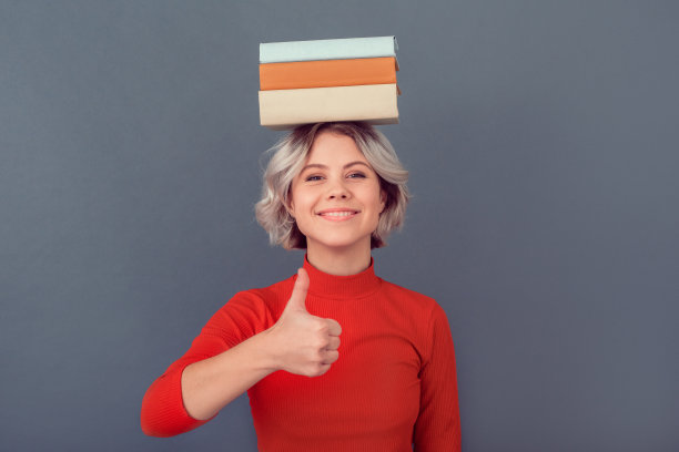 穿着红色衬衫的年轻女子孤立在灰色的墙上图片下载