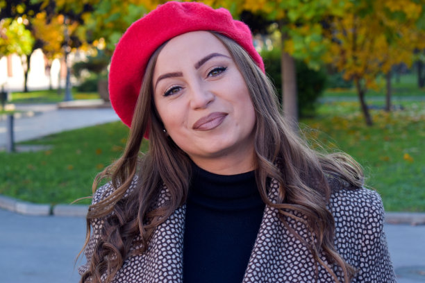 一个在户外戴着红色贝雷帽的女人的肖像图片下载