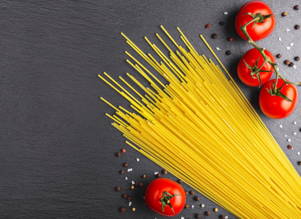 桌上放着意大利面，红番茄，大蒜和香草图片下载