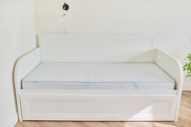 白色的新木制舒适床与床垫女孩在空房间图片下载