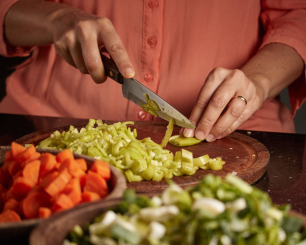 一个女人在木板上切辣椒的特写镜头图片下载