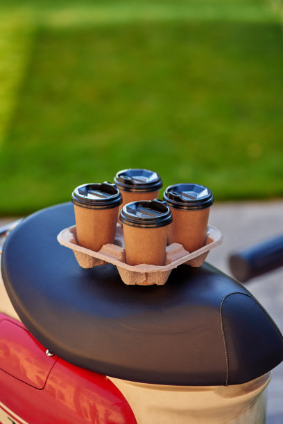 四个咖啡纸杯放在滑板车上，选择性聚焦图片下载