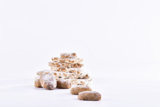 看起来美味的传统西班牙糖果与杏仁牛轧糖块堆在后面在一个轻的背景。糖果和圣诞节概念。图片下载