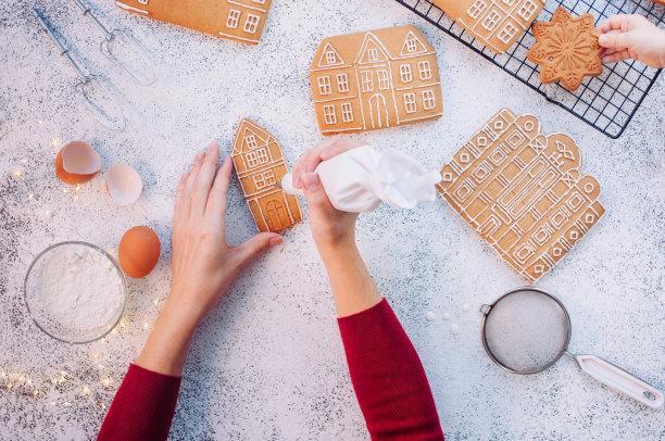 女性双手装饰圣诞姜饼饼屋图片下载