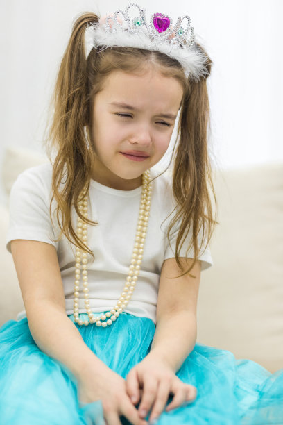 小女孩的照片与黑发戴着皇冠哭泣。图片下载