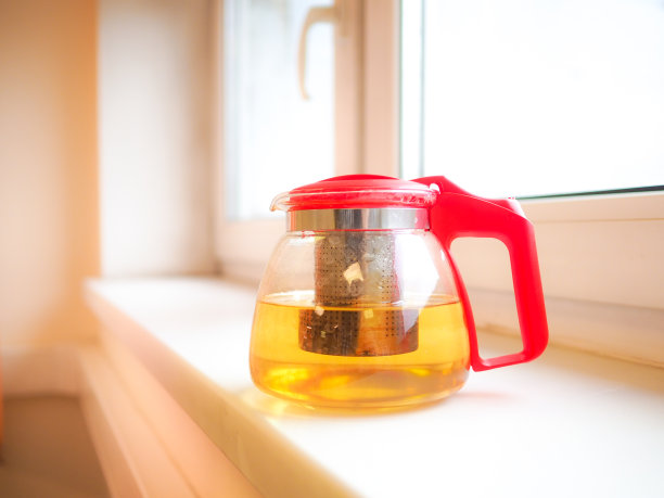 窗台上放着一个透明的玻璃茶壶。图片下载