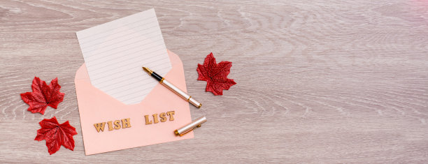 愿望清单。空白的信封纸，木制背景上的钢笔。前视图。网络横幅图片下载