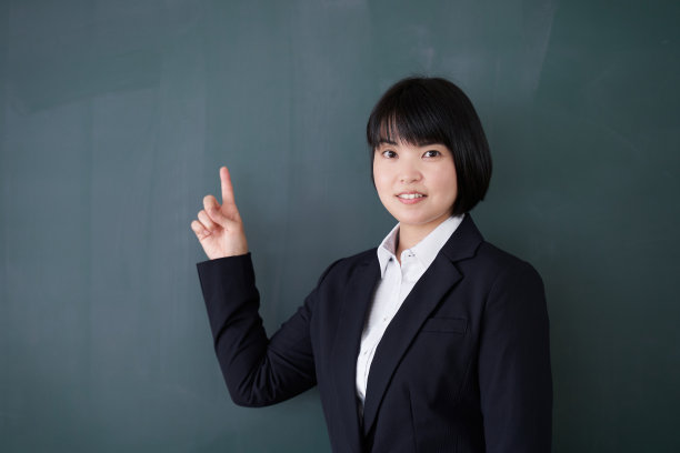 日本女老师指着教室里的黑板图片下载