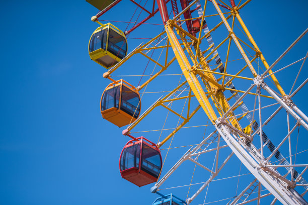 五颜六色的摩天轮孤立在游乐园的蓝天背景。图片下载