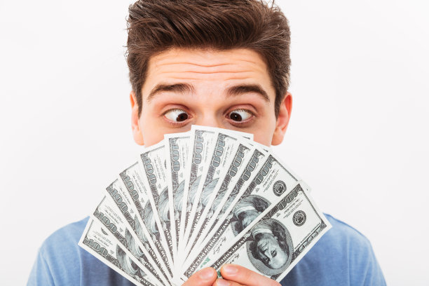 图片特写的有趣的人与黑色短发有乐趣，并在他的脸拿着一扇美元钞票，孤立在白色的墙图片下载