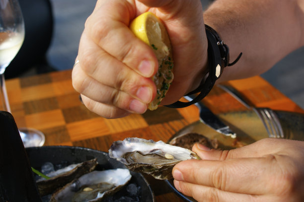 手将柠檬汁挤入新鲜牡蛎中，餐厅中的新鲜牡蛎图片下载