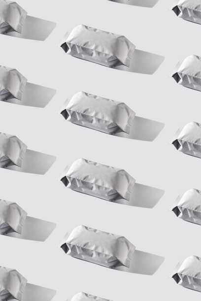 咖啡袋有规律的图案。空白的白色箔袋在灰色的背景上与粗糙的阴影最小风格。包装设计。图片下载