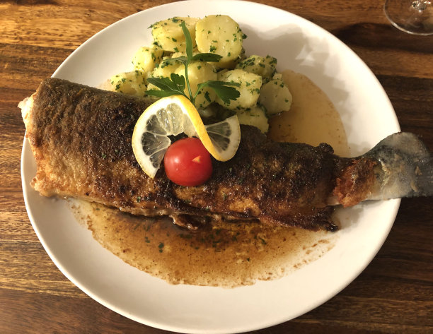 经典菜。用平底锅烤鳟鱼米勒，又称鳟鱼Müllerin风格配以欧芹土豆和肉汁。鳟鱼撒上欧芹，倒上黄油。图片下载