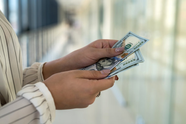 女人在商场里数着我们的钱。商业或购买概念图片下载