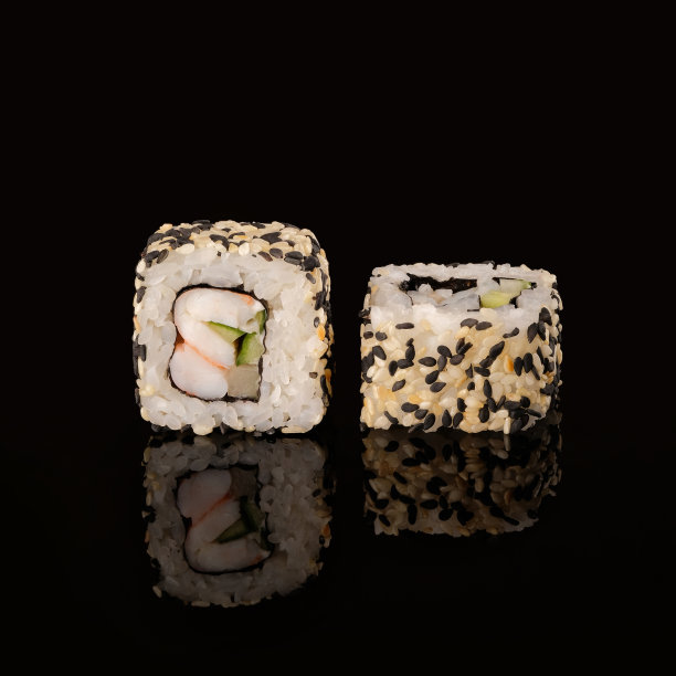 两个寿司卷加利福尼亚ebi在一个黑色的背景反射。图片下载