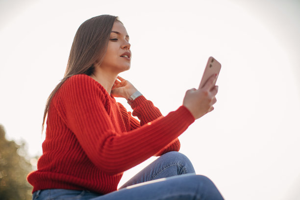 在公园里玩智能手机的美女图片下载