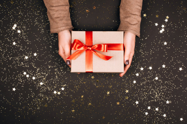 女人手里拿着蝴蝶结的礼盒。图片下载