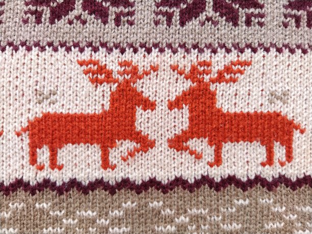 真正的红色针织背景与白色圣诞鹿和雪花图片下载