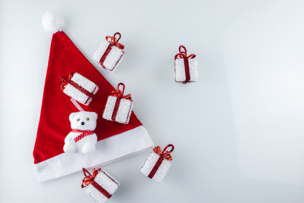 带丝带的圣诞礼盒被放在圣诞老人的帽子上图片下载