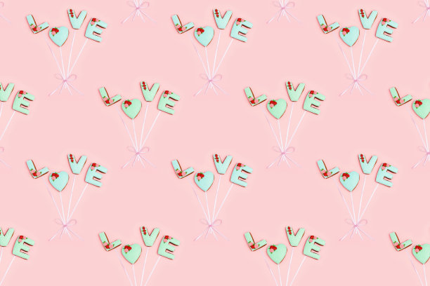 自制姜饼的常规图案，字母“爱”就像气球一样，用淡粉色丝带连接。圣瓦伦丁节的质感。图片下载