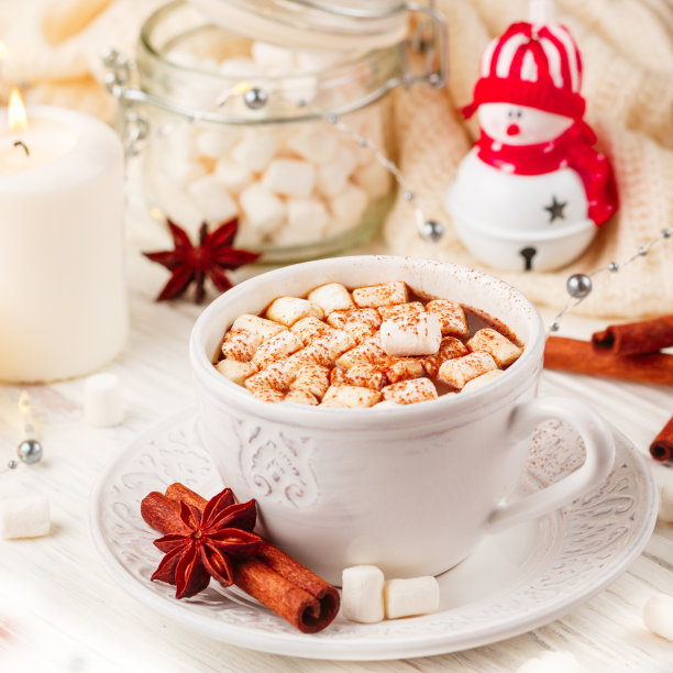 咖啡、可可、热巧克力、棉花糖和肉桂，放在木桌上的白色杯子里。新年。舒适和放松的概念蜡烛，香料和圣诞玩具。广场照片图片下载