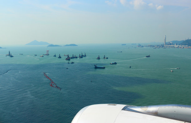 从飞机上鸟瞰香港岛的景观。天空、云和海上的小船合为一体。很好的旅行背景图片下载
