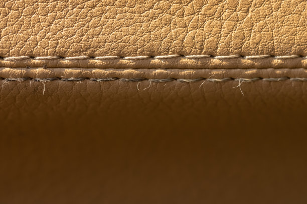 米色旧皮革汽车内饰与缝合近景宏。纺织汽车背景图片下载