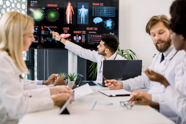 一位年轻的印度医生在一次医学会议上向他的多种族同事们建议，他指着一个大数字屏幕，上面有关于疾病症状和传播的信息和图片图片下载