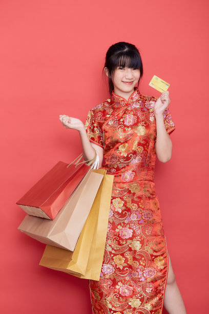 可爱的女人穿着旗袍，在新年向你微笑图片下载